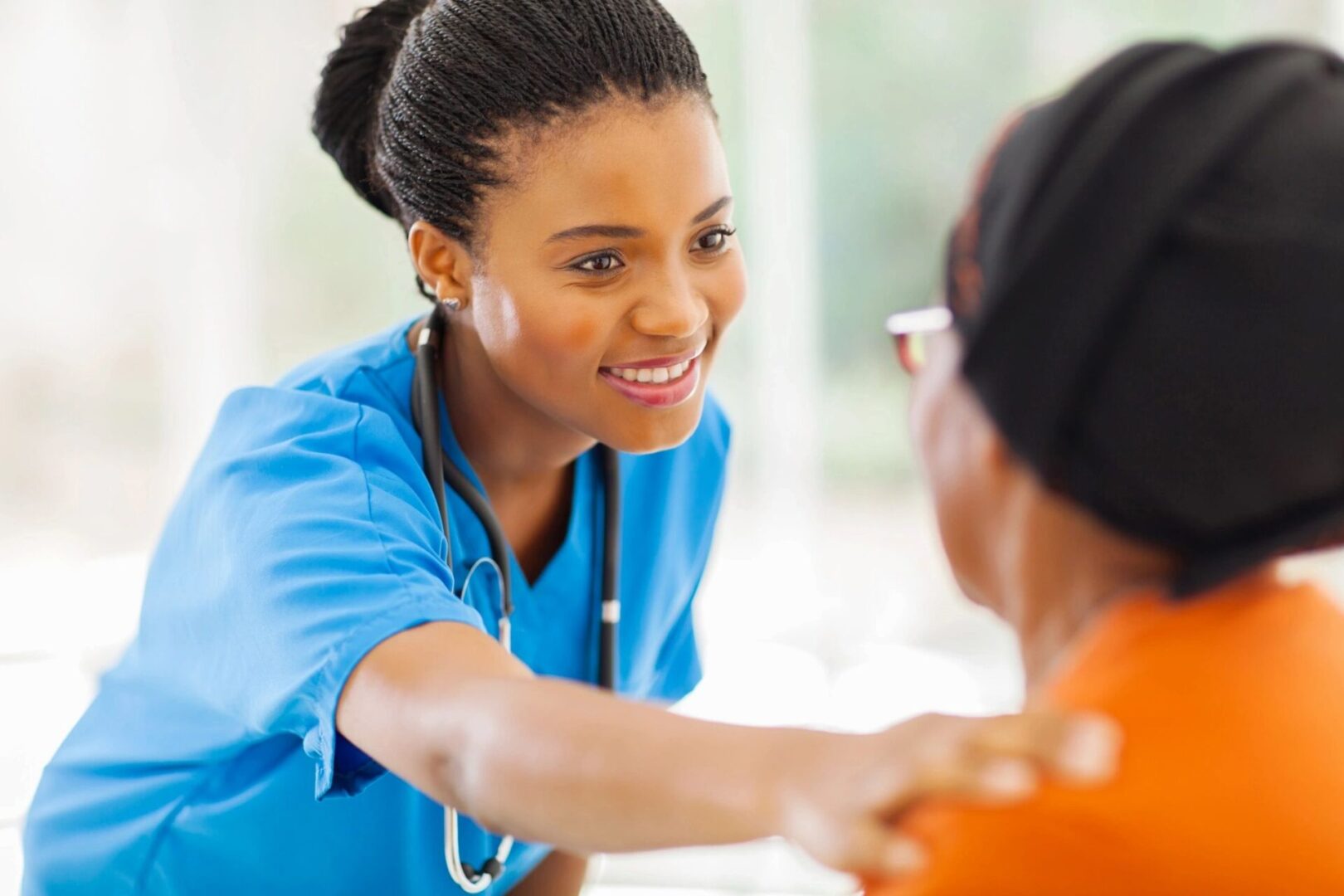 A nurse is smiling as she talks to someone.
