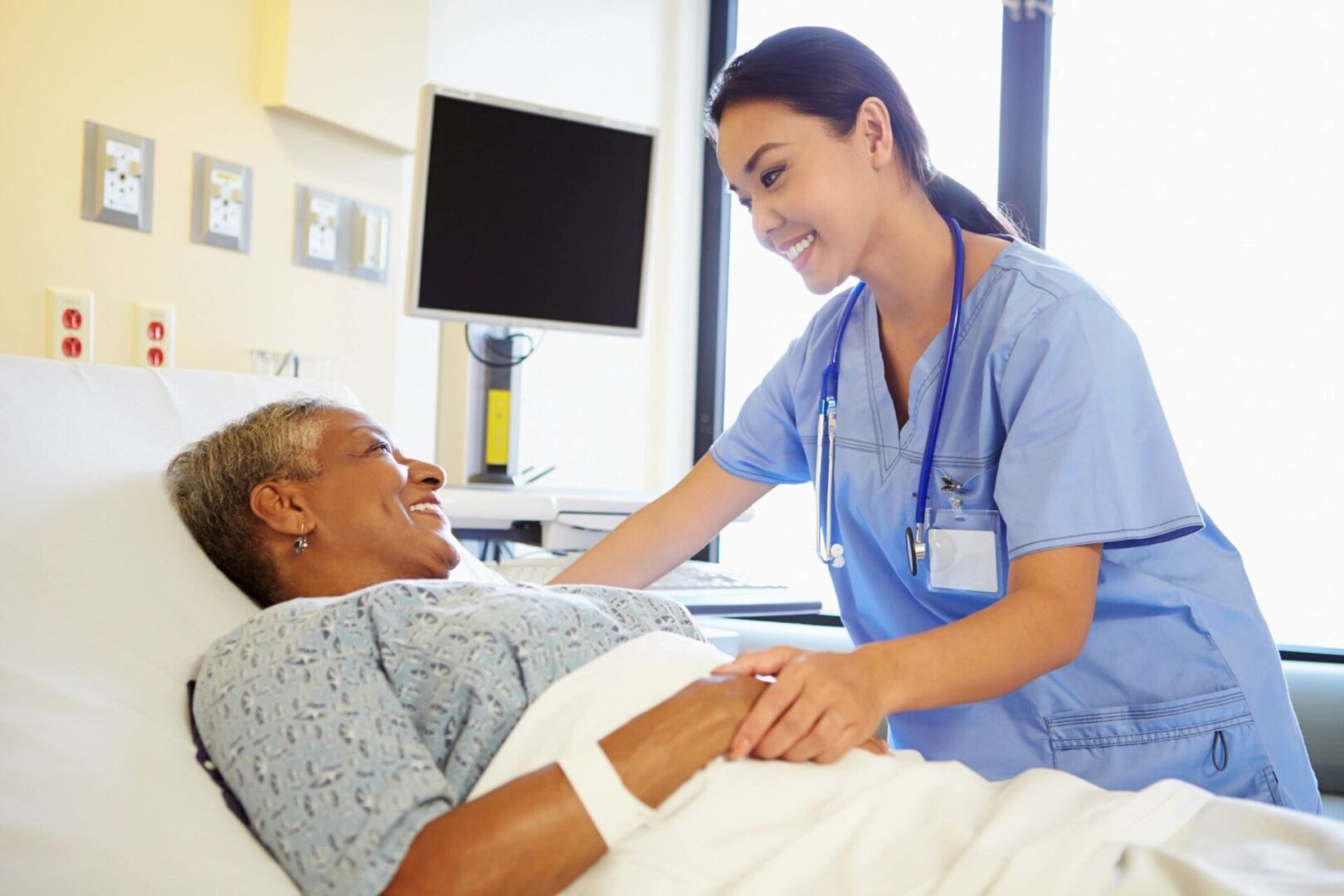 A nurse is caring for an elderly patient in the hospital.